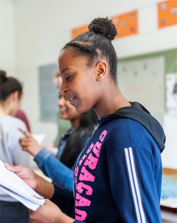Een leerling leest van een schrift.